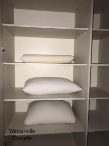 a white book shelf with a white pillow on it at Winterville Gravatá - Flat 1012 in Gravatá