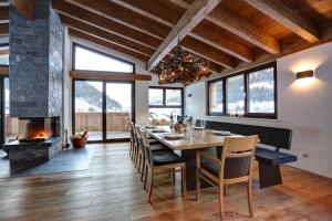 a dining room with a table and a fireplace at Chalet Bella in Pettneu am Arlberg