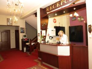 a woman standing at a bar in a restaurant at Hotel Relaks in Wola Ducka