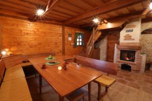 a dining room with a wooden table and a fireplace at Vineyard cottage Zidanca med vinogradi in Otočec