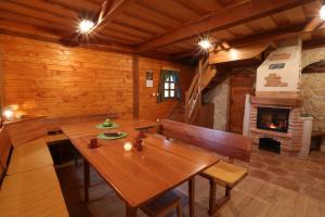 a dining room with a wooden table and a fireplace at Zidanca med Vinogradi in Otočec