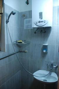 a shower with a chain around a sink in a bathroom at Tash Inn Hostel in Belgrade