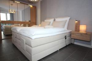 クックスハーフェンにあるWohnen am Yachthafen W46の鏡付きの客室内の大きな白いベッド