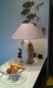 eine Lampe auf einem Tisch mit einer Schale Obst in der Unterkunft la scappatoia in Cavo