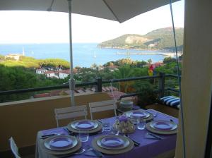 a table with a purple table cloth with a view of the ocean at la scappatoia in Cavo