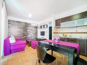 a kitchen and dining room with a purple table and chairs at Apartments Raymond in Sveti Stefan