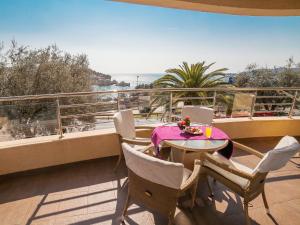 a table and chairs on a balcony with a view at Apartments Raymond in Sveti Stefan