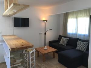 a living room with a couch and a table at Apartamentos DELFIN in Es Caló