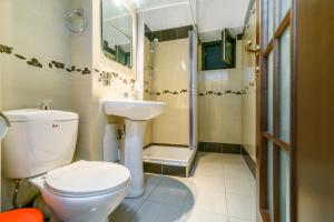 a bathroom with a toilet and a sink and a shower at Bucharest Pedestrian Old Town 3 Bedrooms by Orchid Garden in Bucharest +33 photos