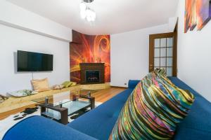 a living room with a blue couch and a fireplace at Bucharest Pedestrian Old Town 3 Bedrooms by Orchid Garden in Bucharest