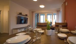 a dining room table with plates and wine glasses at Wohnen am Yachthafen W48 in Cuxhaven