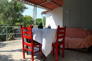 a table with two chairs and a bed on a balcony at Surfers' Cottage in Anavyssos