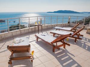 a balcony with tables and chairs on a balcony at Apartments Raymond in Sveti Stefan