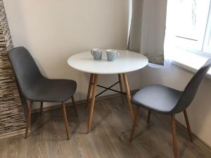 a table with two chairs and a table with two cups on it at Apartmán U Zlaté hroudy in Zlaté Hory