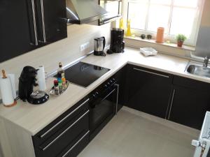 a kitchen with a sink and a stove at Ferienhaus Lemafri Duhnen in Cuxhaven +3 photos