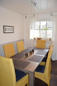 クックスハーフェンにあるFerienhaus Lemafri Duhnenのダイニングルームテーブル(周囲に黄色い椅子付)