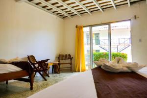 a bedroom with a bed and a large window at El Pacifico Hotel in San Juan del Sur