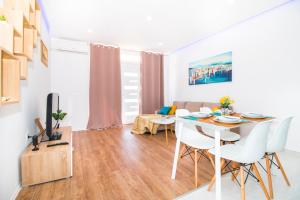 Una pequeña sala de estar con una mesa y sillas. en Blue Sun Apartments, en Kaštela