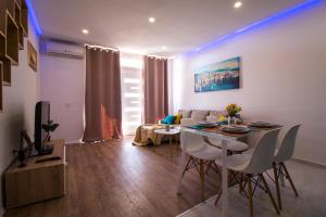 una sala de estar con una mesa, sillas y un sofá en Blue Sun Apartments, en Kaštela