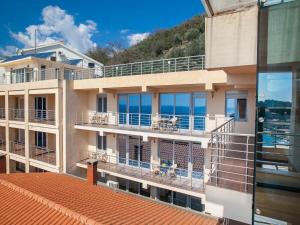 a building with a balcony with the ocean in the background at Apartments Raymond in Sveti Stefan
