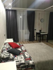 ヴィーンヌィツャにあるКвартира-Студия в Центреのベッドルーム1室(赤い枕のベッド1台付)