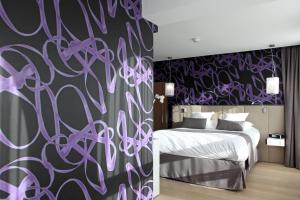 a bedroom with a bed and a purple wall at Best Western Premier Why Hotel in Lille