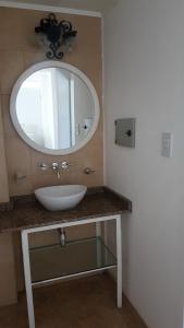 a bathroom with a white sink and a mirror at CH Lar Alojamiento in Mendoza