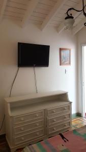 a flat screen tv on a wall above a dresser at CH Lar Alojamiento in Mendoza