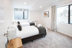 1 dormitorio con 2 camas y ventana en Dungarvon Street Apartments, en Wanaka