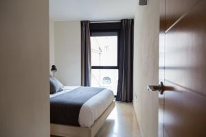 バレンシアにあるNew Aloha Apartment Center Valenciaのベッドルーム1室(ベッド1台付)、窓付きのドアが備わります。
