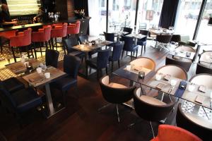 a restaurant with tables and chairs and a bar at Best Western Premier Why Hotel in Lille