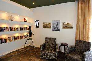 a room with two chairs and a camera and books at Tony's Beach in Vromolithos