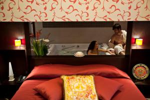 a mirror above a bed with a man and woman in a bath tub at Agriturismo Il Granaio Hotel & SPA in Modica