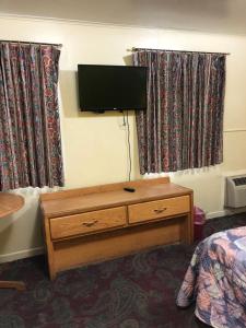 ein Schlafzimmer mit einem TV und einer Kommode mit einem Bett in der Unterkunft Budget inn in Portland