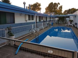 una gran piscina con un edificio azul en Hotel Los Cardenales, en Chillán