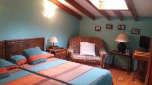 a bedroom with a bed and a chair at Casa Llorente in Meré