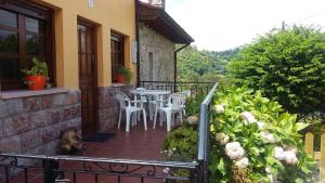 a balcony with a table and chairs on a house at Casa Llorente in Meré