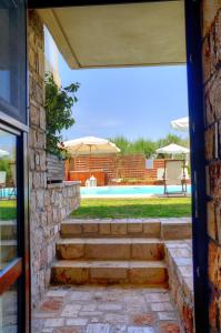 a view from the door of a house with stairs leading to a pool at Enalio Suites in Lechaio