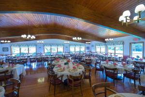 un salón de banquetes con mesas y sillas blancas en Lukans Farm Resort, en Hawley