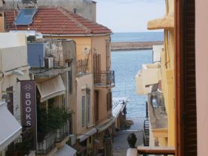 - une vue sur une rue avec des bâtiments et l'eau dans l'établissement Narkissos 'SUPERB', à La Canée