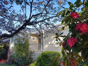 a white house with a white fence and flowers at Alkira in Leongatha