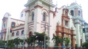 un grande edificio bianco con palme di fronte di Guesthouse Dos Molinos B&B a San Pedro Sula