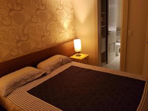a bedroom with a bed and a lamp on a table at Landscape Beira Mar - 1804 Gold B in Fortaleza +23 photos