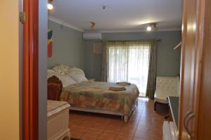 une chambre avec un lit, une chaise et une fenêtre dans l'établissement Heritage Resort, à Weipa