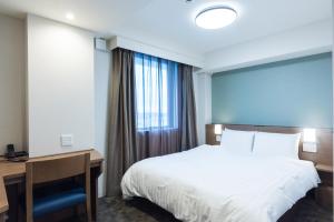 Postel nebo postele na pokoji v ubytování Dormy Inn EXPRESS Sendai Seaside
