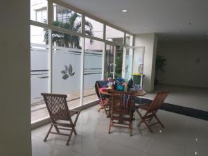 uma sala de jantar com mesa, cadeiras e janelas em DSR Margonda Residence 3 Apartment em Depok