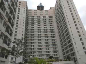 um edifício branco alto com um relógio em cima em DSR Margonda Residence 3 Apartment em Depok