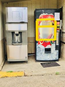 zwei Kühlschränke sitzen neben einer Wand in der Unterkunft Sunset Inn Longview in Longview