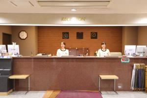 two women are sitting at a counter in a restaurant at Chitose Daiichi Hotel in Chitose