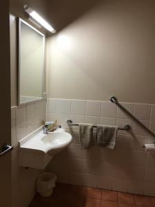 une salle de bain avec un lavabo et un miroir dans l'établissement Heritage Resort, à Weipa